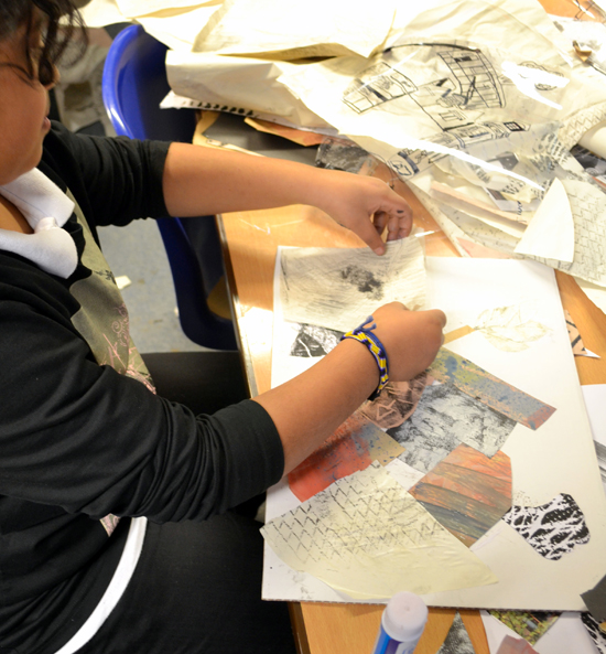 Pupil uses textured paper created in the morning session to make a back ground for their new building