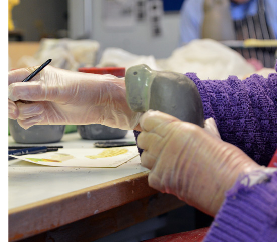 Having smoothed her bird, Jenny paints coloured slip before firing her Robin