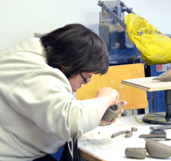 Emma making progress - applying another coil to her emerging clay bird
