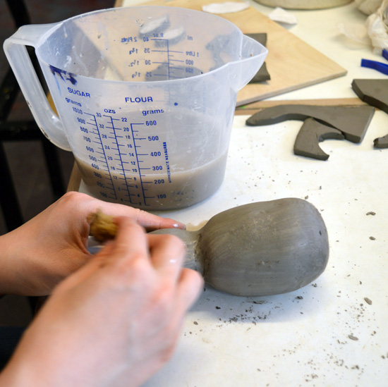 Smoothing the clay with a wet sponge