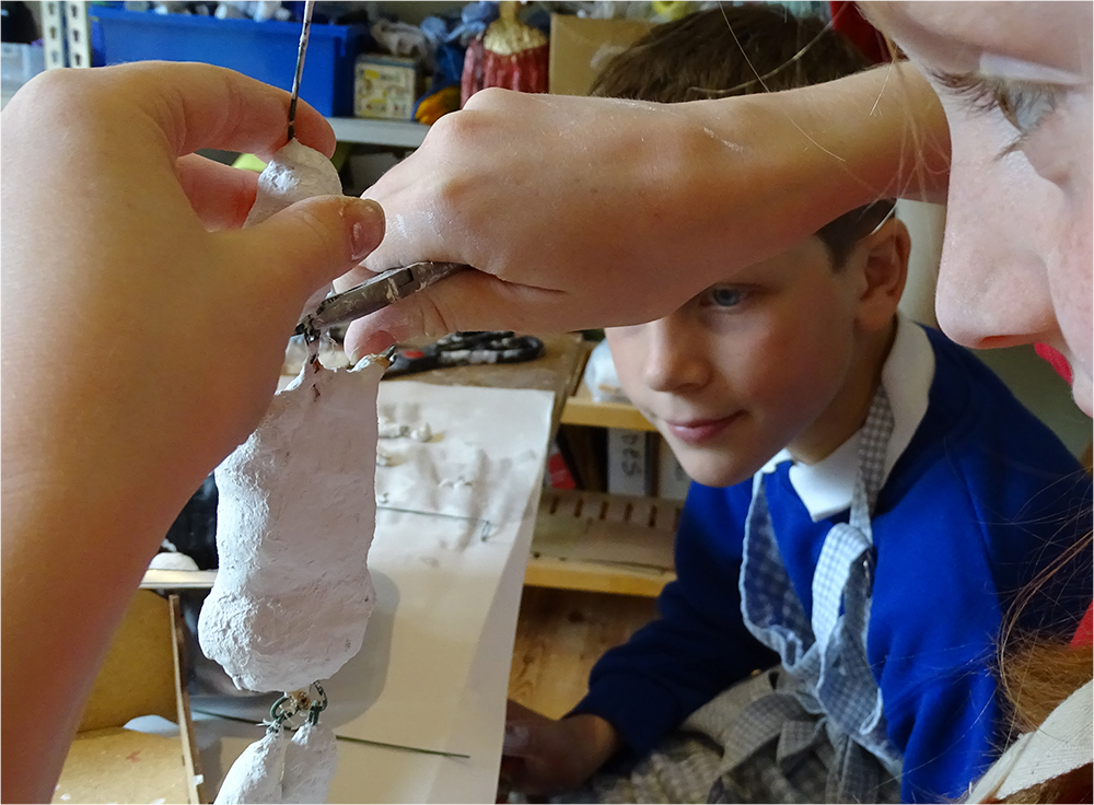 Once the pieces are set, use pliers to bend the wires into hoops. Feed each limb into a hoop, and again use the pliers to secure