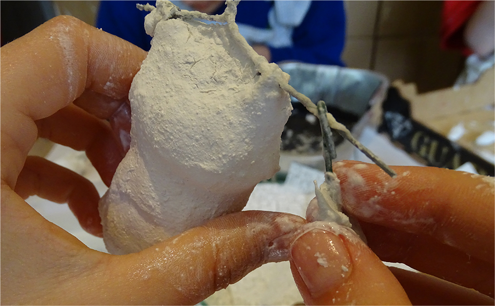 Once the pieces are set, use pliers to bend the wires into hoops. Feed each limb into a hoop, and again use the pliers to secure