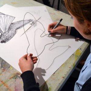 Lottie tracing shadows cast by her wire 'drawing' of a moth