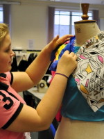 Pinning two colours of cloth to the mannequin