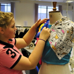 Pinning two colours of cloth to the mannequin