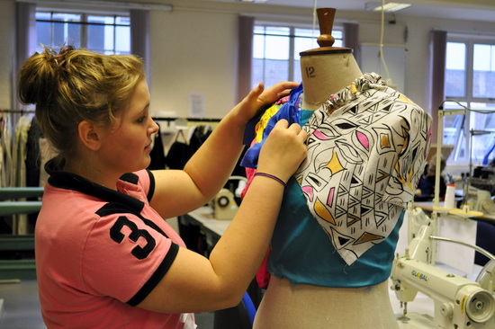 Pinning two colours of cloth to the mannequin