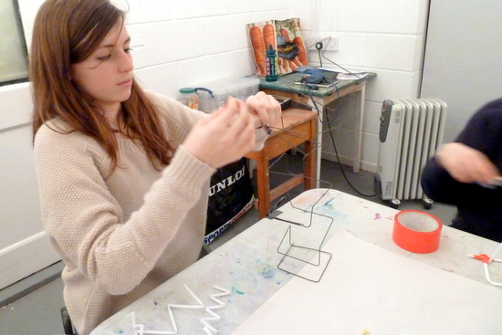 Making vertical sculptures: student working up from the base