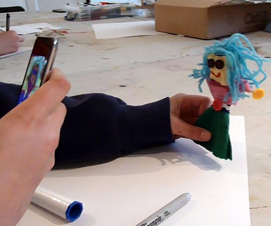 Animating puppets: Nina takes a photo of her puppet on a device