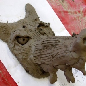 Step 7 – some of the children built up a nose and snarl lines on the muzzle by blending sausages on clay to the surface, then fur texture was added using a fork.