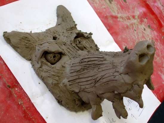 Step 7 – some of the children built up a nose and snarl lines on the muzzle by blending sausages on clay to the surface, then fur texture was added using a fork.