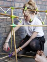 Girl works on construction with electric tape and cane