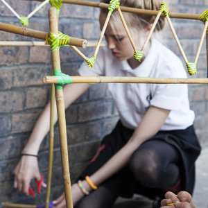 Girl works on construction with electric tape and cane
