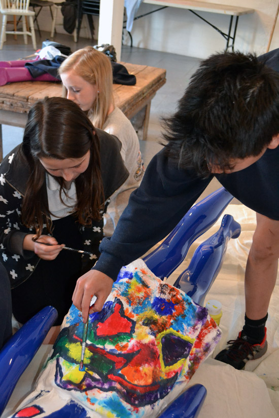 Students paint the back of a model