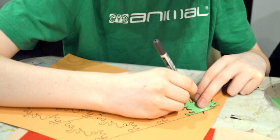 Student at AccessArt's Experimental Drawing Class works on a tessellated design using a stencil he made