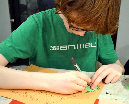 Student at AccessArt's Experimental Drawing Class works on a tessellated design using a stencil he made