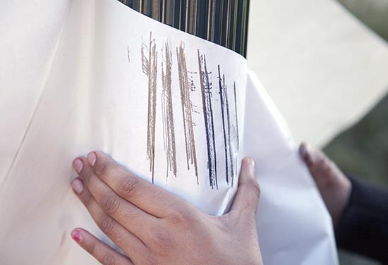 Close up of rubbing being taken by a pupil outside the classroom