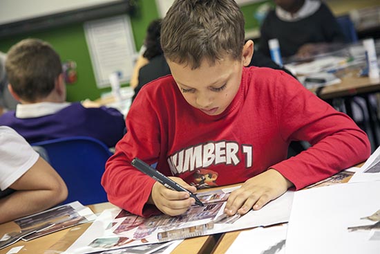 Pupil traces over his collage in acetate with a permanent marker