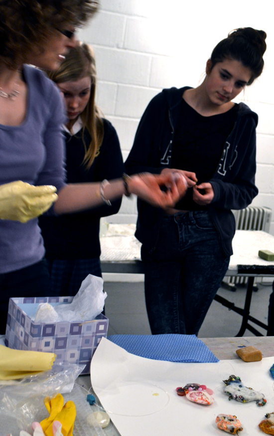 Andrea shows students her work and ideas about embedding small objects into three dimensional felt sculptures