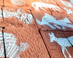 Sgraffito, or ‘scratching’ is a technique which is an excellent way to reinforce mark making with all age groups.
Drawing into leather hard red clay tiles to create designs using mark-making can be even more effective when done through a white earthernware slip to reveal the red clay beneath.