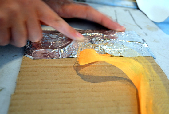 Teenagers stuck down textures onto a piece of cardboard