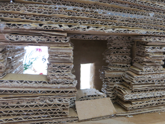 The corrugated cardboard, placed on its side, creates a wonderful sculptural building material which lets the light through