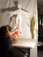 Teenager at AccesArt's Experimental Drawing Class preforming in the shadow puppet play