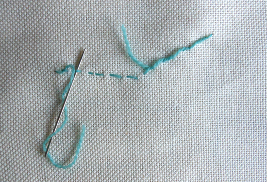 Weaving the tail of thread under the stitches to secure the end