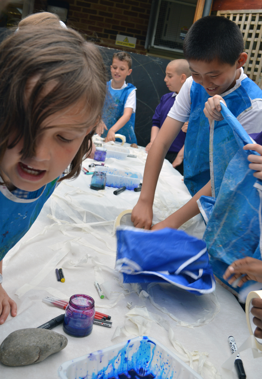 Children working with masking tape to make long strokes