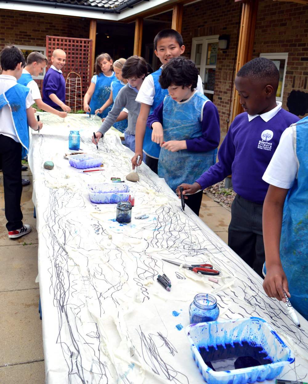 To get a sense of the length of the paper and prevent the youngsters feeling confined to one part of the sheet, they walked in procession mark making along the length and breadth of the paper