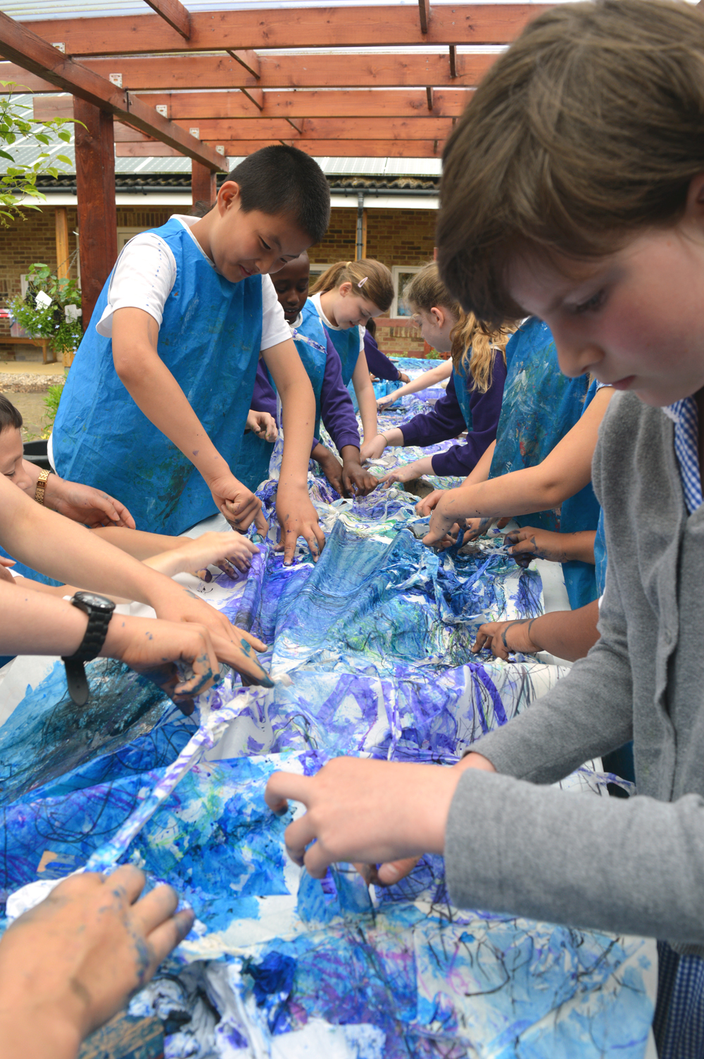 Pupils then worked carefully together to peal off the masking tape now buried under layers of marks and texture