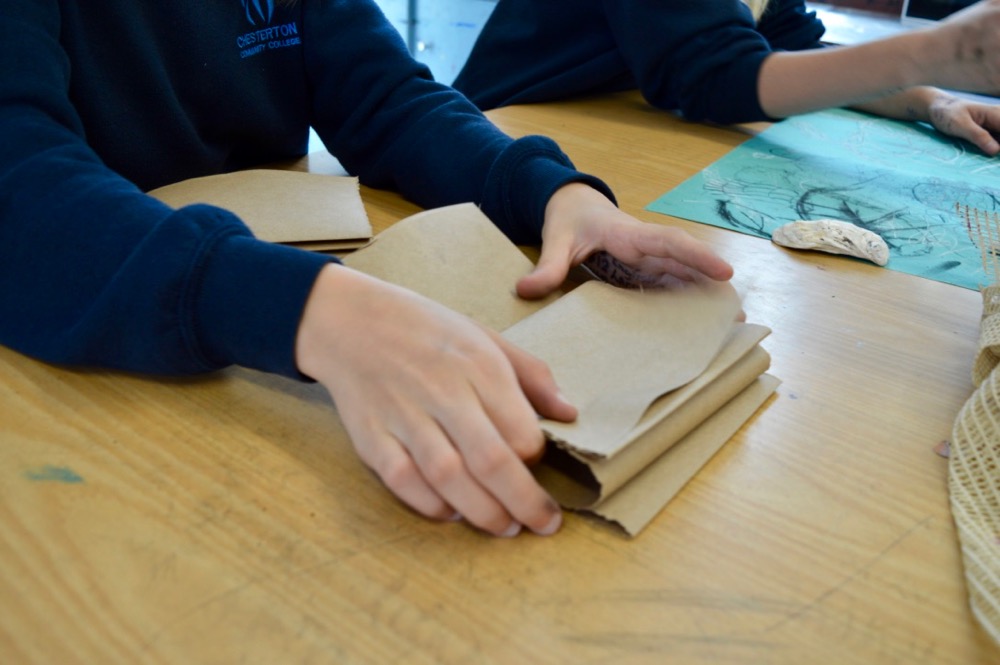 Folding brown paper to create a zigzag sketchbook 