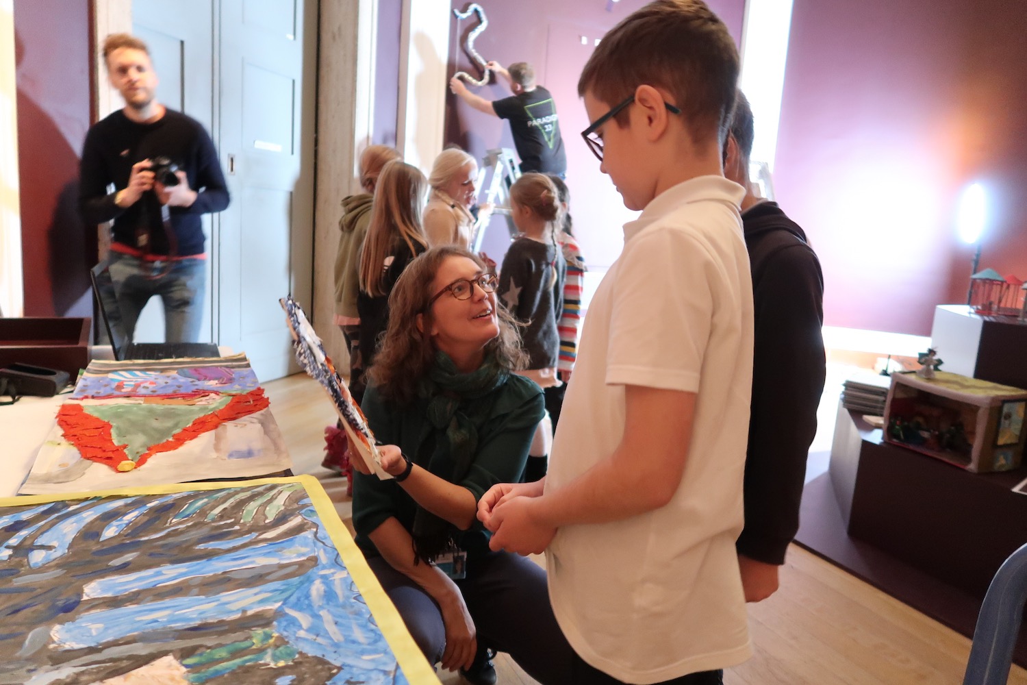 Kate Noble shows children other children's artwork in the Octagon Gallery 