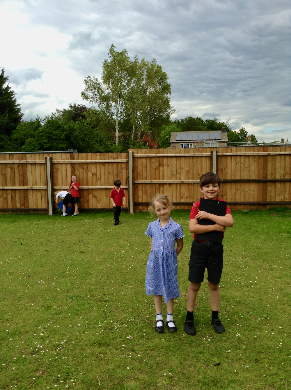 Children looking at trees and filling in a fact sheet