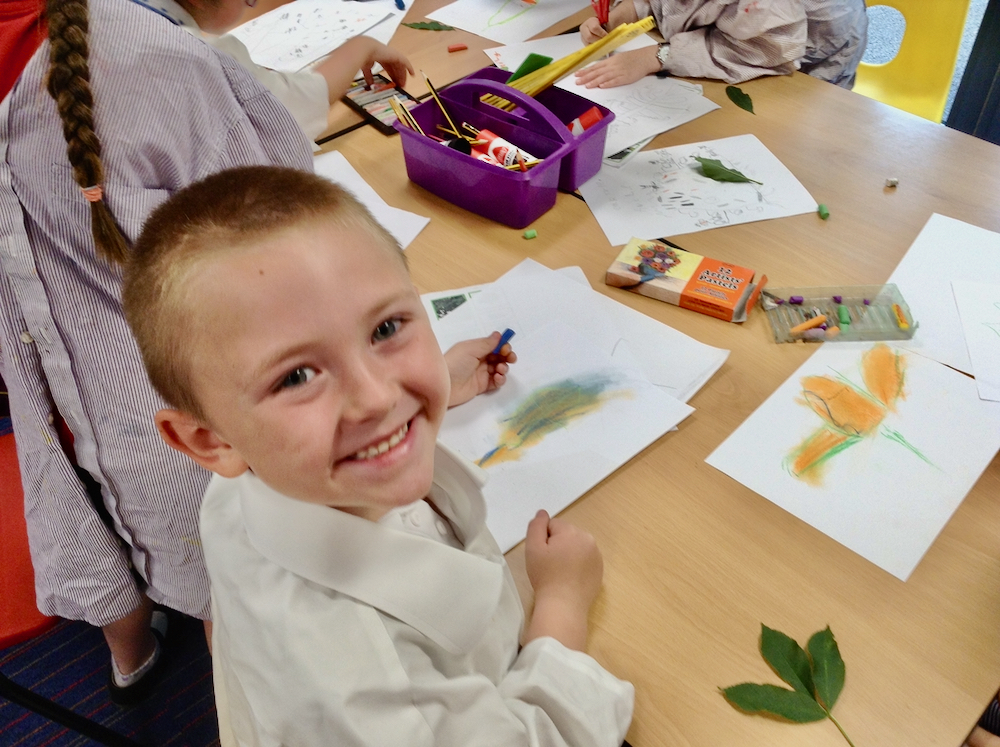 Year One boy at Hauxton Primary School drawing leaves with pastels with Pamela Stewart for Inspire