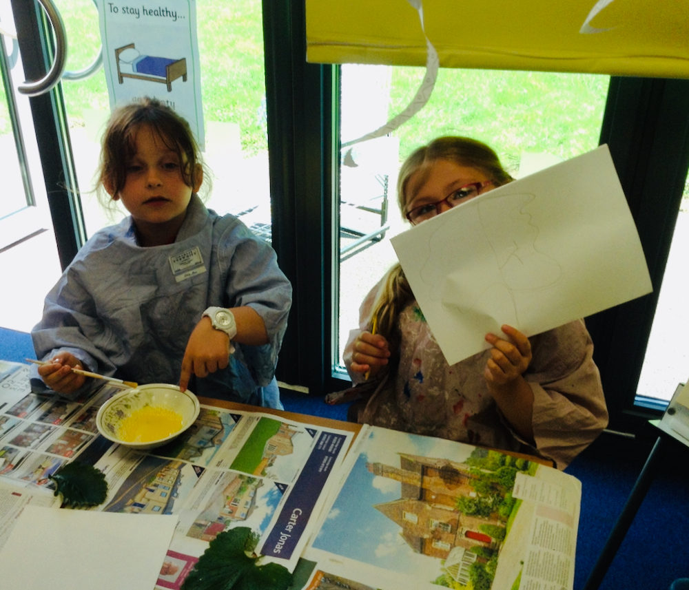 One girl mixes egg and the other paints with egg and powder paint at Hauxton Primary School for Inspire with Pamela Stewart 