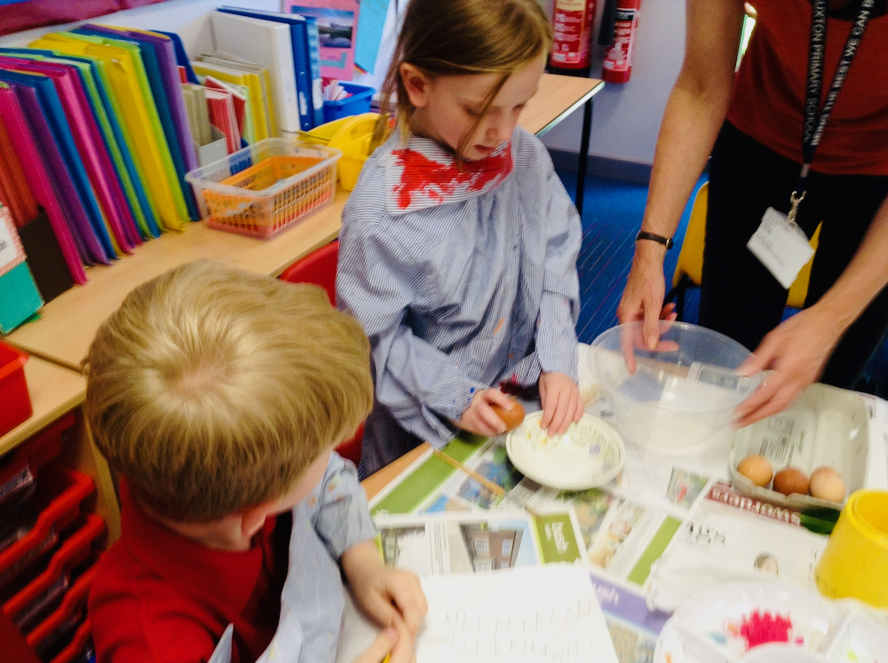 A girl at Hauxton Primary cracking an egg to mix and bind powder paint with pamela stewart - Inspire