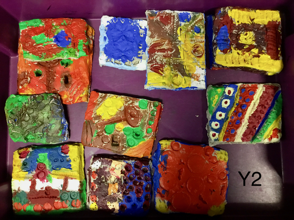 A selection of clay tiles which has been colourfully painted by Year Two Pupils 