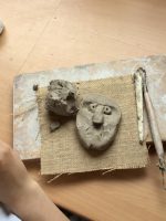 A clay head being created on a school table top by a Year Four pupil with school clay and wooden tools