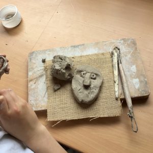 A clay head being created on a school table top by a Year Four pupil with school clay and wooden tools