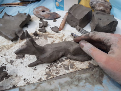 Making a form of a fox out of clay