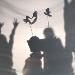 Shadow puppets on sticks held high