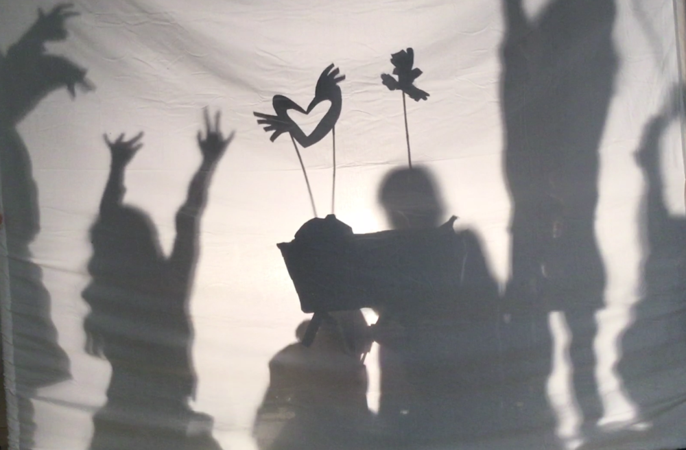 Shadow puppets on sticks held high