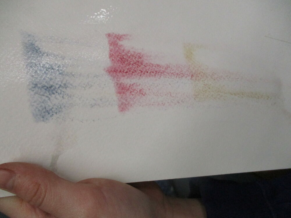 Adding water to water colour paint to make the colours bleed into one another.