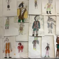 A wall display of costume designs for Bottom from A Midsummer Night's Dream.