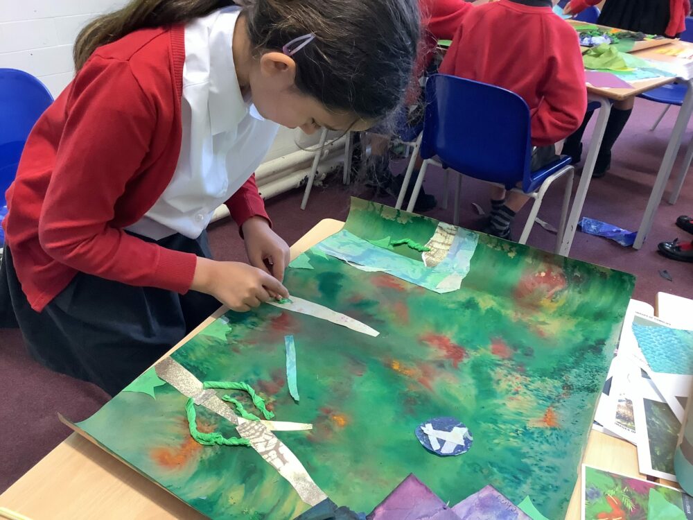 Using paper to create tree trunks on a mixed green background.