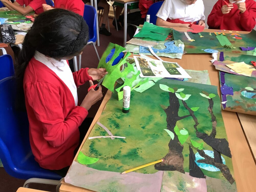Using scissors to cut out leaves for a collage.
