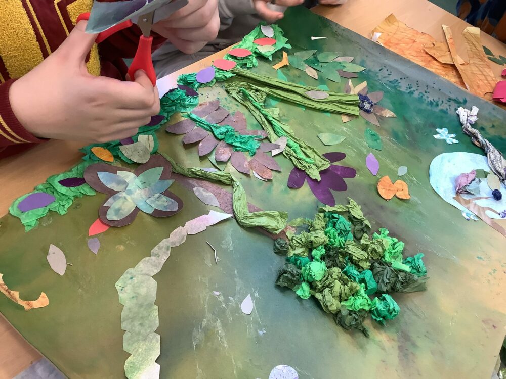 Cutting paper shapes for a collage using scissors
