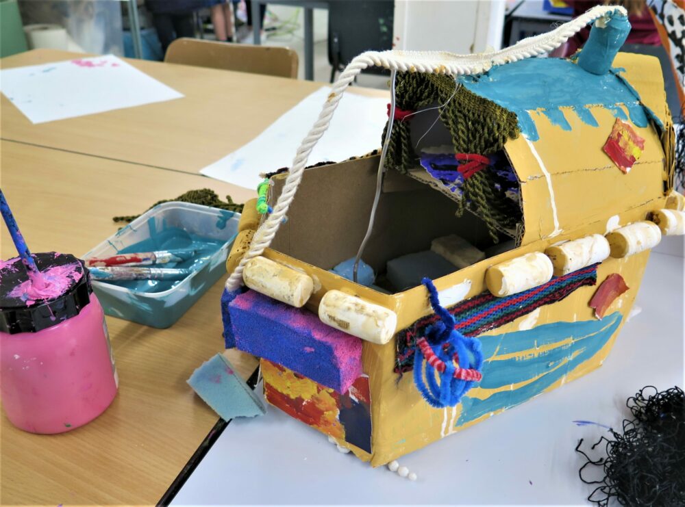 A painted boat made from card and mixed media.