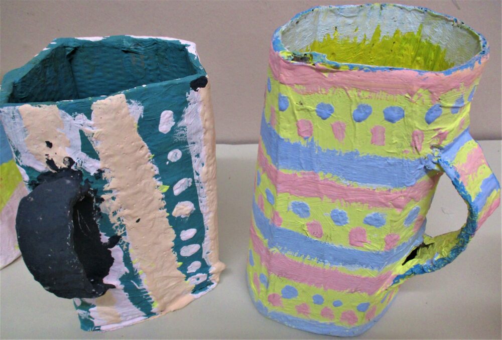 Two painted cardboard cups together.