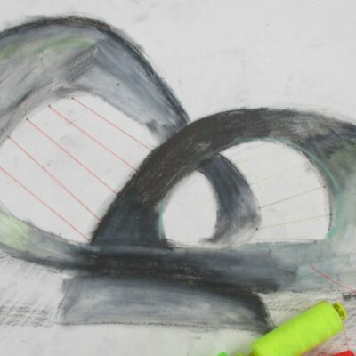 Threading fishing wire through a charcoal drawing.